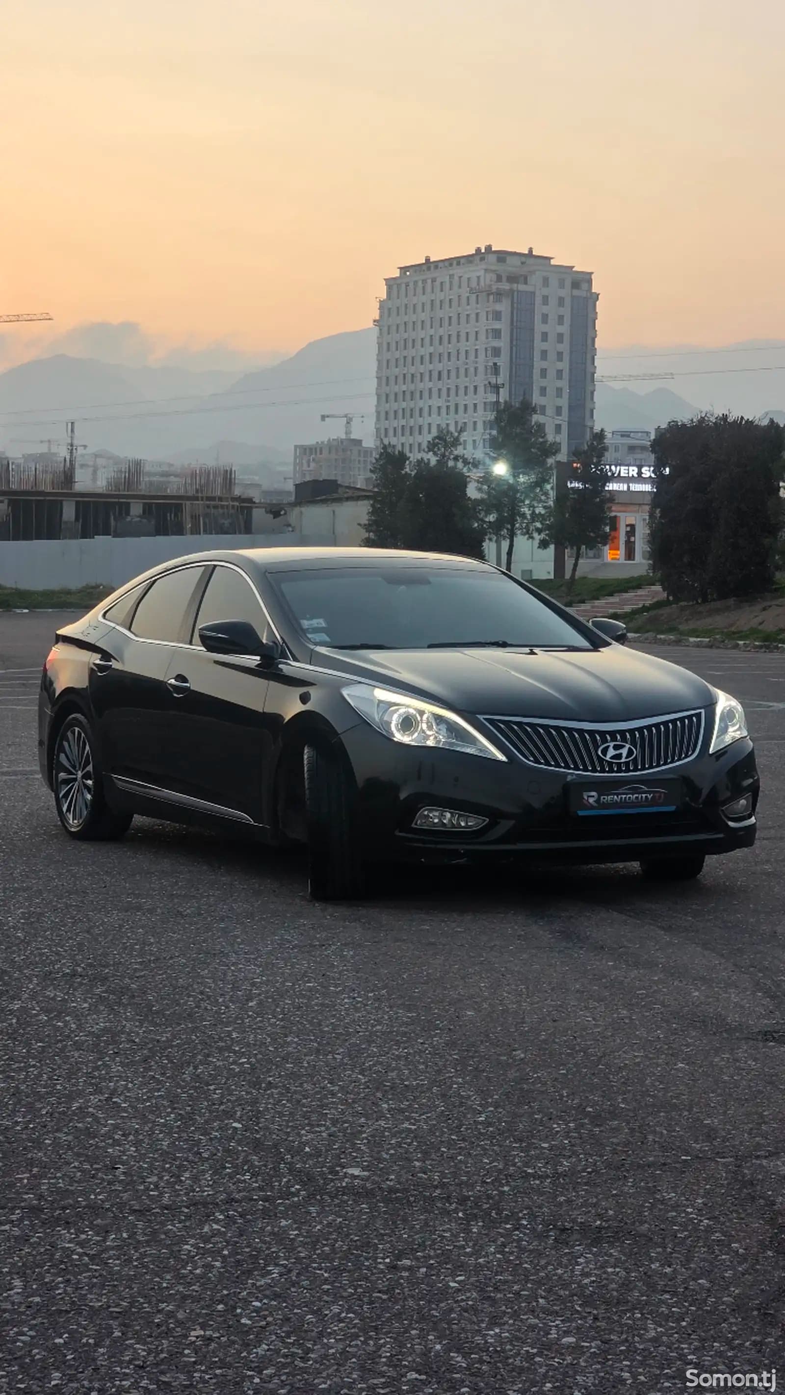 Аренда Hyundai Grandeur 2014 в Худжанде — вид спереди на закате